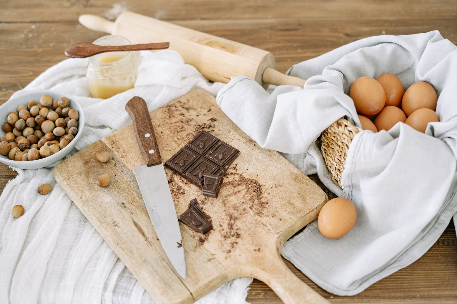brown wooden chopping board with knife and white textile