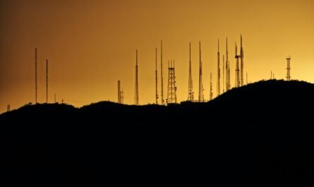 silhouette photo of transmission tower on hill