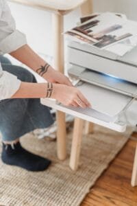 woman placing paper in printer for making photos