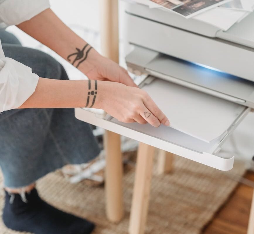 woman placing paper in printer for making photos
