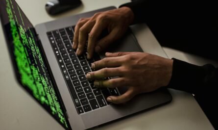 crop cyber spy hacking system while typing on laptop